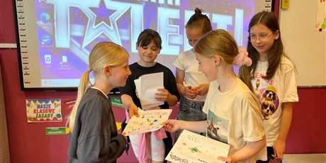 Powiększ grafikę: Dziewczynki wręczają dyplomy i nagrody
