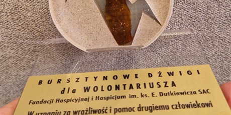 Powiększ grafikę: na stole stoi statuetka Bursztynowe dźwigi