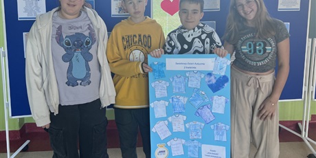 Powiększ grafikę: Uczniowie prezentują plakat o Dniu Autyzmu.