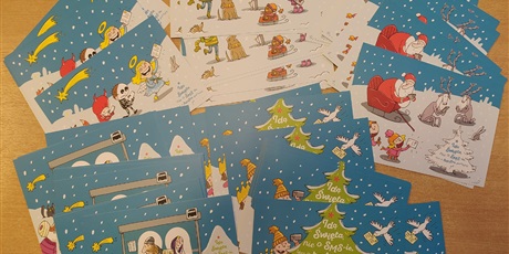Powiększ grafikę: Kartki bożonarodzeniowe ułożone na stole.