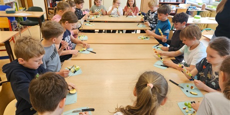 Powiększ grafikę: Dzieci z klasy 2c pracujące przy wspólnym stole.
