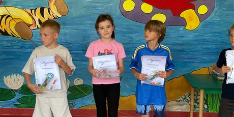 Powiększ grafikę: Uczniowie w dłoniach trzymają dyplomy i nagrody.