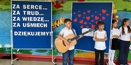 Powiększ grafikę: Chłopiec gra na gitarze i śpiewa.