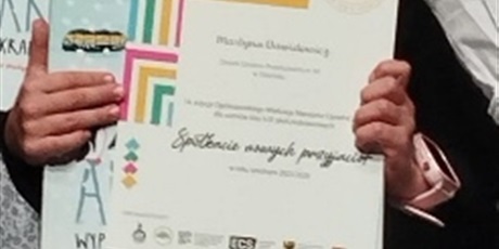 Powiększ grafikę: Dziewczynka trzyma dyplom i nagrodę.