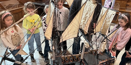 Powiększ grafikę: Dzieci z kl.1b uważnie słucchają opowieści przewodnika w sali Dworu Artusa.