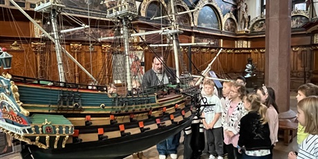 Powiększ grafikę: Dzieci z kl.1b uważnie słucchają opowieści przewodnika w sali Dworu Artusa.