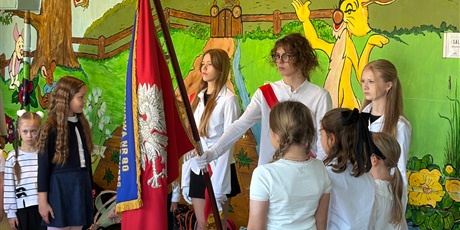 Powiększ grafikę: Uczniowie stoją wokół sztandaru szkoły.