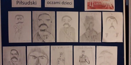 Powiększ grafikę: na niebieskiej tablicy przypięte są prace plastyczne ze szkicem J.Piłsudskiego