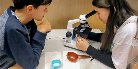 Powiększ grafikę: dziewczyna bada mikroplastik pod mikroskopem 