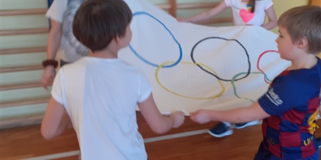 Powiększ grafikę: Czworo dzieci niesie flagę olimpijską