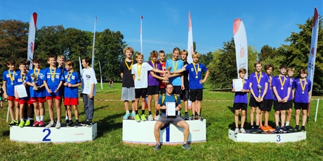 Powiększ grafikę: Zawodnicy stoją na podium z medalami na szyi.