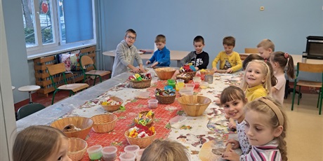 Powiększ grafikę: Dzieci przy stole przygotowują świąteczne pierniki. 