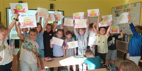 Powiększ grafikę: Uczniowie klasy prezentują pokolorowane "Ordery Uśmiechu"